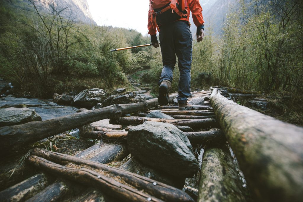 Hombre cruzando puente de madera haciendo geocaching
