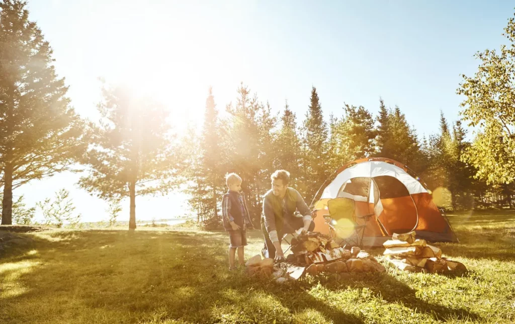 Padre e hijo montando la zona de camping en la naturaleza. Consejos para acampar con niños.